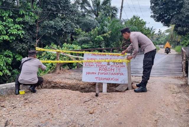 Demi Keselamatan Warga, Anggota Polsek Ranto Peureulak Pasang Garis Polisi di Jembatan Yang Rusak